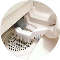 お風呂排水口をブラシ掃除する写真