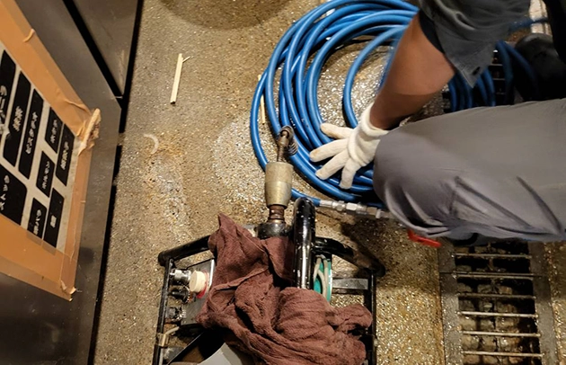 守山市飲食店の厨房床の詰まり清掃を行う写真