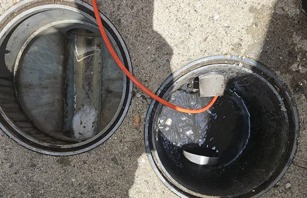 草津市の油が固着した排水管を高圧洗浄する様子