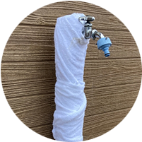 布を巻いてぬるま湯をかけた蛇口の写真