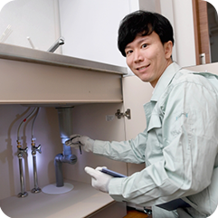 キッチン配管を調べる作業員